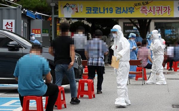 신종 코로나바이러스 감염증이 확산하고 있는 27일 광주 동구보건소 선별진료소에 코로나19 검사를 받으려는 시민들이 줄지어 대기하고 있다.