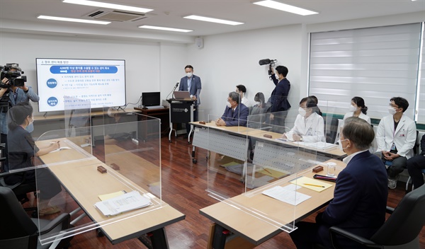 문재인 대통령이 28일 서울 중구 국립중앙의료원 수도권 병상 공동대응 상황실에서 이창준 중앙사고수습본부 환자병상관리반장으로부터 생활치료센터 현황에 대해 보고받고 있다. 