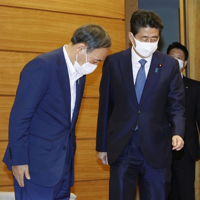 아베 신조 일본 총리가 28일 오후 총리관저에서 열린 기자회견에서 사의를 공식 표명했다. 사진은 아베 총리에게 인사하는 스가 요시히데 관방장관(왼쪽).