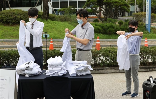 지난 23일, 서울 종로구 서울대병원 대학의원 본관 앞에서 정부의 의료정책에 반대하는 전공의들이 의사 가운을 탈의하고 있다.  