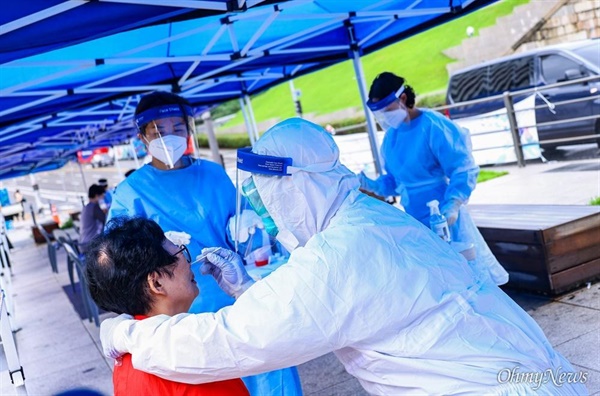 지난 9일 남대문시장 케네디 상가에서 상인 8명이 코로나19 집단 감염이 발생하자 10일 오전 서울 남대문시장 입구에 차려진 선별진료소에서 상인들이 검사를 받고 있다.