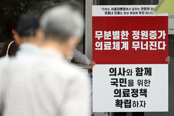 정부의 보건의료정책에 반대하는 대한의사협회의 집단휴진이 셋째 날을 맞은 28일 서울대학교 병원에서 전문의가 손팻말을 들고 있다.