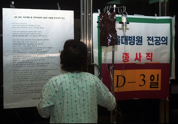 의약분업에 반대해 전공의들이 2000년 6월 20일 총사직하기로 선언한 가운데 6월 18일 오후 서울대병원 본관에 붙은 대자보를 한 환자가 살펴보고 있다.