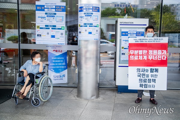 정부의 의사정원 확대 등 보건의료정책에 반대하는 대한의사협회의 집단휴진이 진행 되고 있는 31일 오후 서울 종로구 서울대학교 병원에서 한 전문의가 일인 시위를 하고 있다. 