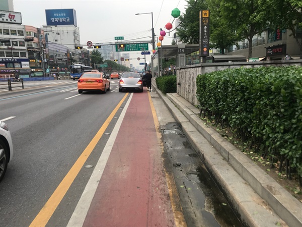 종로3가역에서 자동차가 자전거 도로에 정차하고 있다.