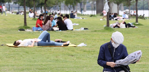 정부가 코로나19 방역을 위한 사회적 거리두기 '2.5단계' 조치를 1주일 연장한 가운데 6일 오후 서울 여의도한강공원에서 한 시민이 신문을 보고 있다.