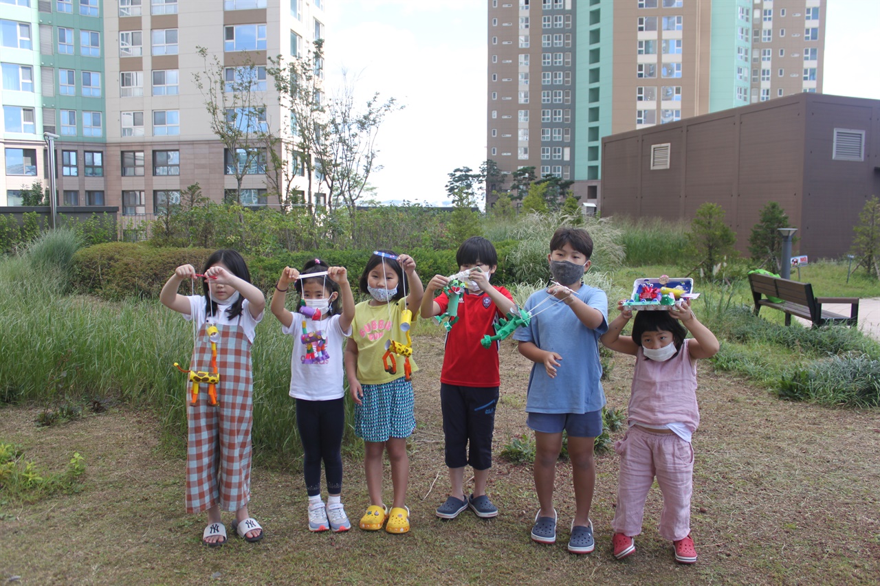 일산의 한 아파트에 거주 중인 아이들의 모습. 코로나19 예방을 위해 모두 마스크를 착용하고 체험 활동한 작품을 흔들어보이고 있다. 