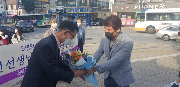 전장곤 전교조 충남지부장이 김종선 교사에게 복직을 축하하며 꽃다발을 건네고 있다. 왼쪽 김종선 교사, 오른쪽 전장곤 지부장 