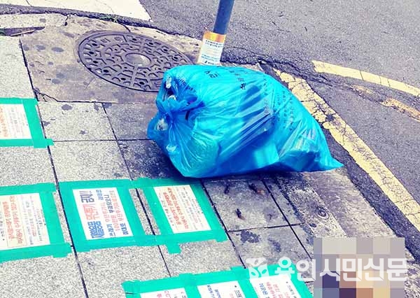 기흥구의 한 인도에 쓰레기를 버리지 말 것을 경고하는 안내문이 곳곳에 붙어 있다.