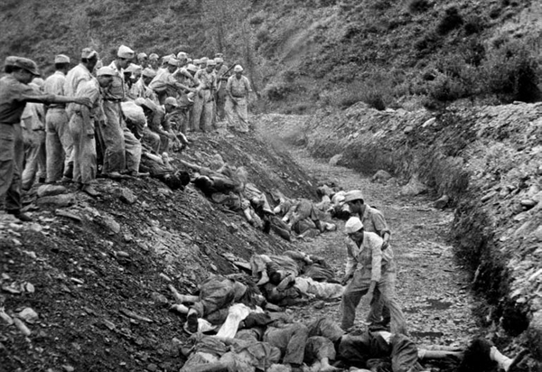 1950년 산내 골령골 민간인 학살 현장. 구덩이 위에서는 시신을 내던지고 구덩이 아래에서는 던져진 시신을 나란히 정돈하고 있다.  산자락 바로 아래로 폭 3m, 깊이 2m 가량의 'ㄱ'자 형태의 구덩이가 길게 뻗어 있다. 미 극동군사령부 연락장교 애버트(Abbott) 소령이 찍고, 고 이도영 박사가 1999년 말 NARA에서 발굴했다.