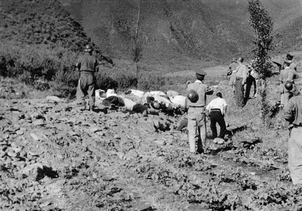 1950년 산내 골령골 민간인 학살 현장. 구덩이 위에서는 시신을 내던지고 구덩이 아래에서는 던져진 시신을 나란히 정돈하고 있다. 산자락 바로 아래로 폭 3m, 깊이 2m 가량의 'ㄱ'자 형태의 구덩이가 길게 뻗어 있다. 미 극동군사령부 연락장교 애버트(Abbott) 소령이 찍고, 고 이도영 박사가 1999년 말 NARA에서 발굴했다.