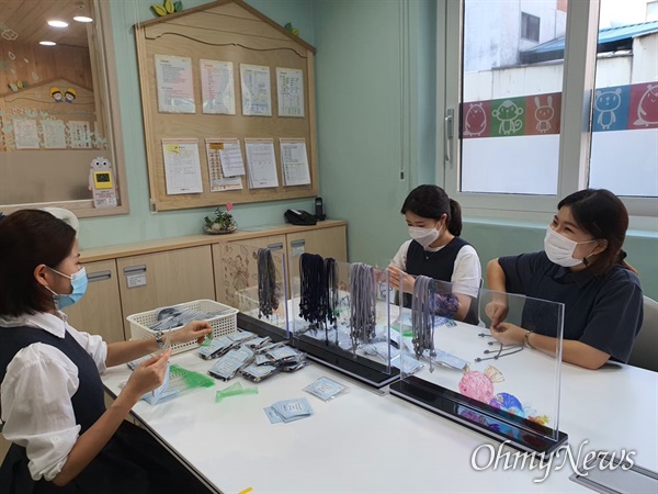 경북대학교병원 어린이집 김영 원장과 교사들이 마스크 스트랩을 만들고 있다.