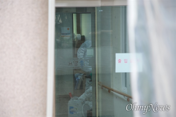 14일 오전 부산 북구 만덕동 해뜨락요양병원에서 직원들이 방역복장으로 대응하고 있다.