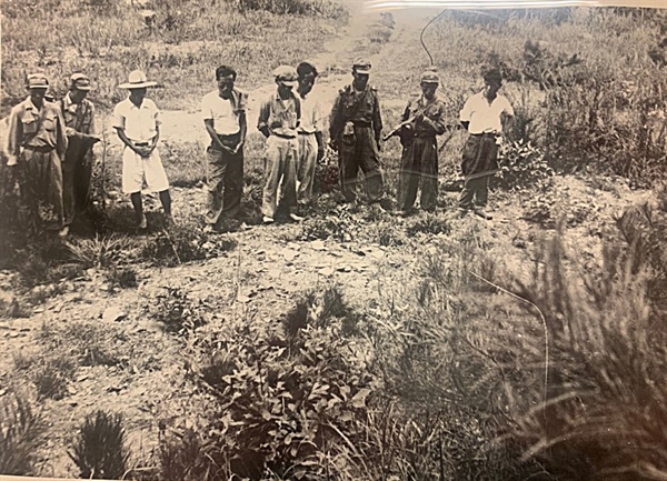  [발굴사진] 1950년 대전 골령골에서 군경이 민간인을 학살한 직후 현장 모습이 담긴 사진이 확인됐다. 총을 멘 북한군 5명과 마을주민으로 보이는 4명이 한 줄로 늘어서 시체가 묻힌 구덩이를 응시하고 있다.1950년 7월 또는 8월, 대전을 점령한 북한군과 함께 골령골 현장을 방문한 영국 <데일리 워커>의 앨런 위닝턴 기자가 찍은 사진이다.