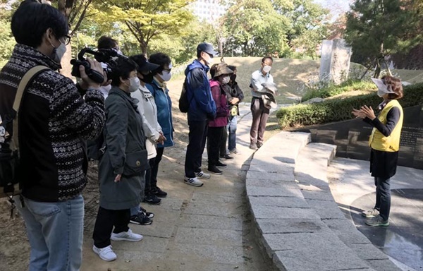 김순덕 할머니의 그림 ‘끌려감’을 새긴 위안부 추모 조형물 ‘대지의 눈’ 앞에서 해설을 듣는 여행자들.
