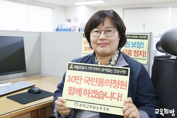 이주연 교사가 전교조 사무실에서 세월호참사 7주기까지 성역없는 진상규명을 위해 10만 국민동의 청원에 함께 하겠습니다라는 문구를 들고 입법청원 동참을 알리고 있다. 