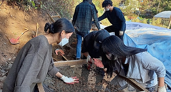 20일, 성미산학교 11학년과 12학년(고등학교 2, 3학년 과정) 학생들이 대전 골령골에서 흙을 채에 거르며 유해 파편을 찾고 있다.
