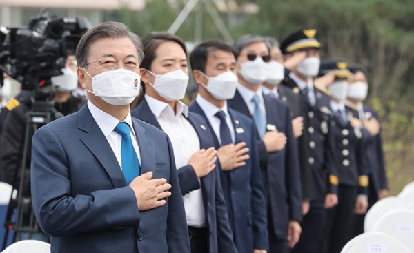 문재인 대통령이 21일 충남 아산시 경찰인재개발원에서 열린 제75주년 경찰의 날 기념식에서 국기에 경례하고 있다. 