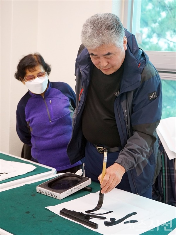 왼손으로 서예를 하고 있는 김재우 씨. 힘있고 시원시원한 필체가 돋보였다.