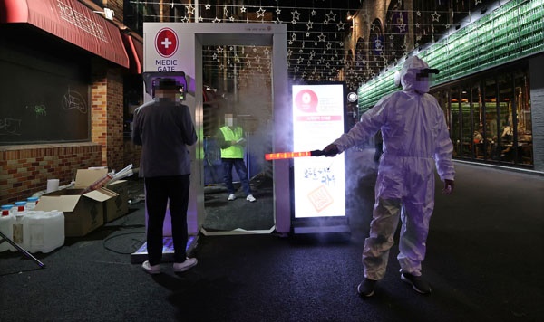핼러윈 데이를 하루 앞둔 30일 오후 서울 용산구 이태원 거리 입구에 설치된 신종 코로나바이러스 감염증(코로나19) 방역 게이트를 시민들이 통과하고 있다.