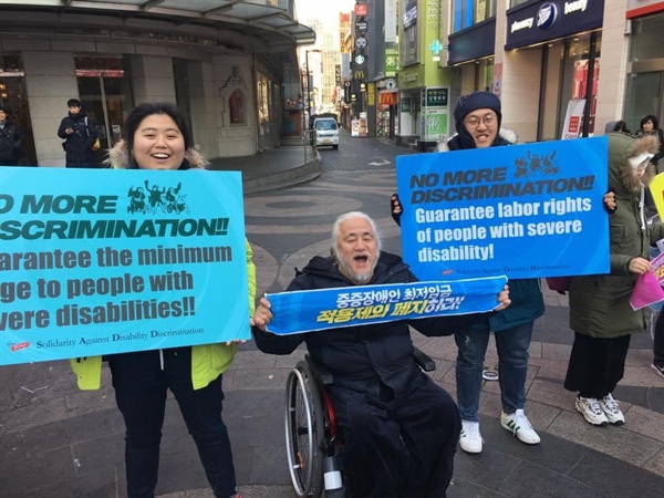 중증장애인 최저임금 적용제외 제도 폐지를 요구하는 퍼포먼스 중인 정다운 활동가(사진 맨 좌측). 