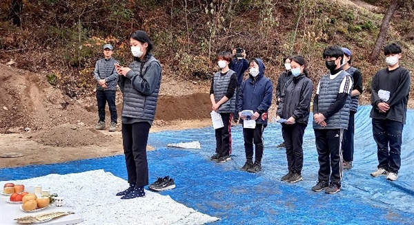 성미산 학교 11학년과 12학년(고등학교 2, 3학년) 학생 10여명이 6일 유해발굴 봉사활동을 마친 뒤 약식 추모식을 개최하고 있다.
