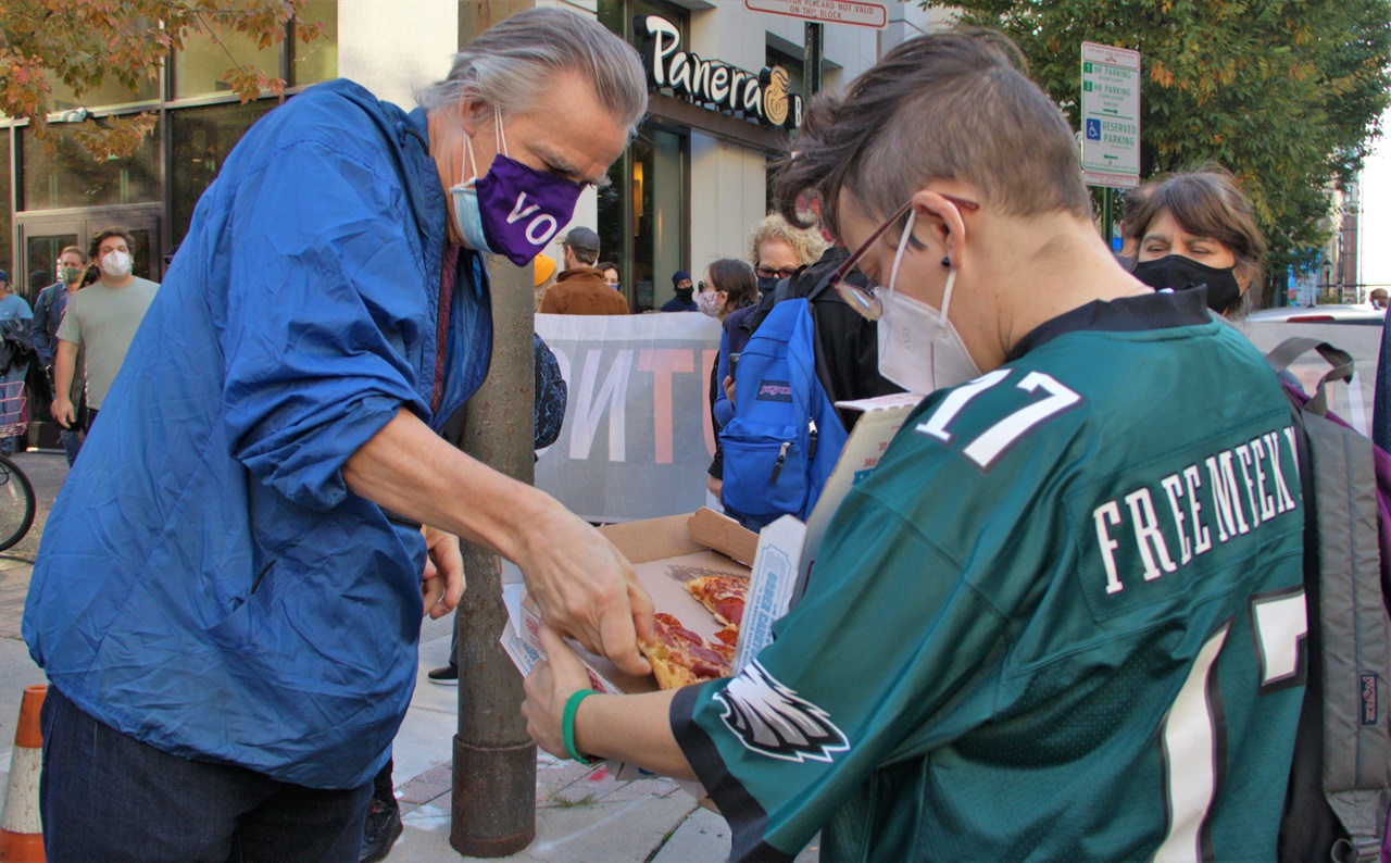 바이든 후보 지지자들이 개표장인 펜실베니아컨벤션센터 개표장 앞에서 집회도중 누군가 제공한 공짜피자를 나눠먹으며 느리게 진행되고 있는  막바지 개표결과를 기다리고 있다.