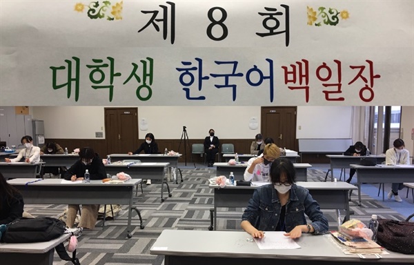            제8회 한국어 백일장 대회가 열리고 있는 고베한국교육원 강당 모습입니다. 신형코로나 감염을 예방하기 위해서 미리 소독이나 방역을 실시하고 넓은 강당에서 널찍이 자리를 띄워 앉았습니다.？