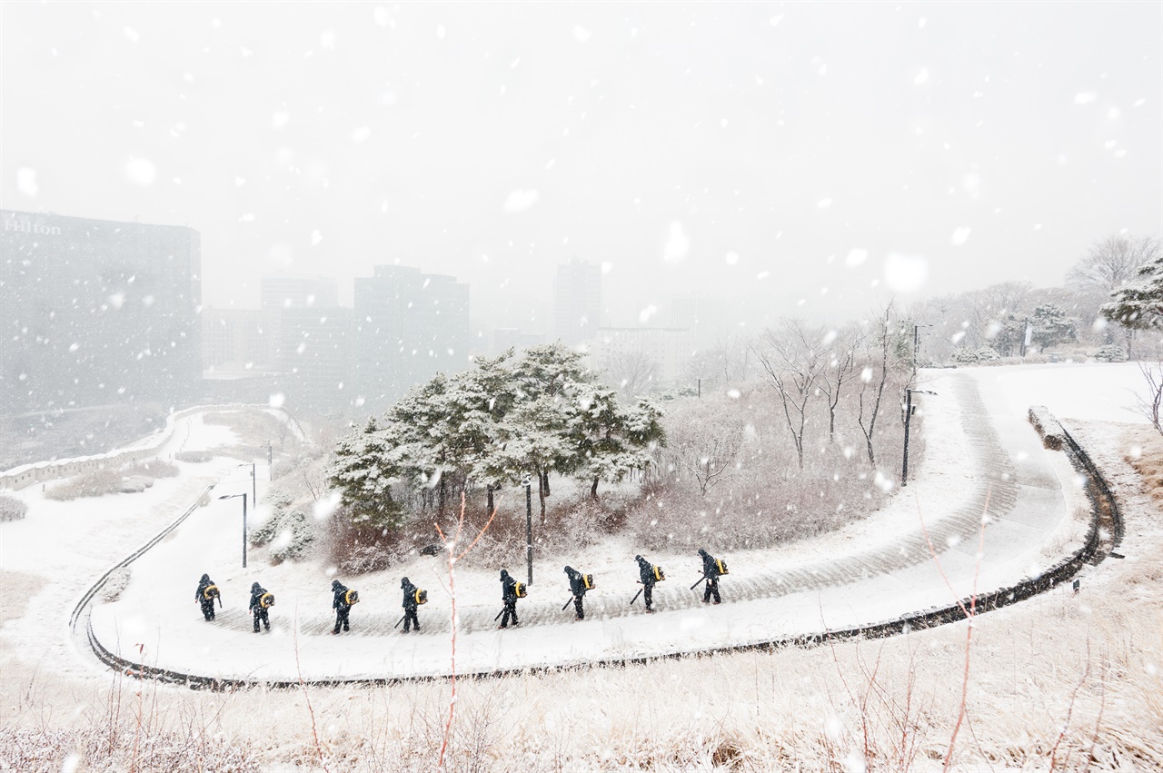 남산공원의 회현쪽 들머리, 공원관리소 직원이 눈을 치우고 있다.