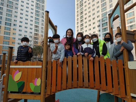 왕진희(49) 입주민 대표회장(왼쪽에서 네 번째 뒤)이 아이들과 함께 강저 리슈빌 아파트 광장 앞 놀이터에서 아이들과 사진 찍고 있다.