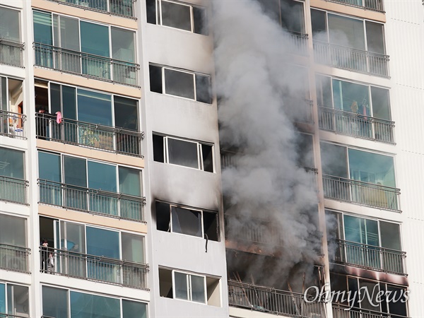 부산 해운대구의 한 20층 아파트에서 갑자기 불이 나 소방관들의 구조작업이 펼쳐졌다. 화재 현장 바로 옆 주민들이 수건을 흔들며 "살려달라"를 외치고 있다.