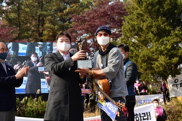 민중가수 박준이 김호철을 대신해  상을 받고 있다.
