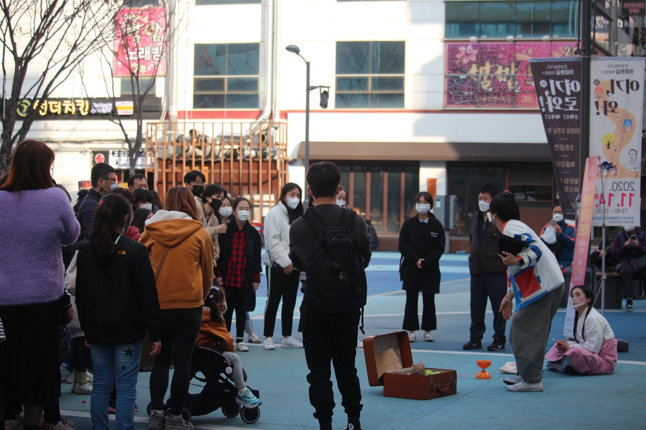 거리 광장에서 사람들이 자유롭게 공연을 관람하고 있는 모습이다.