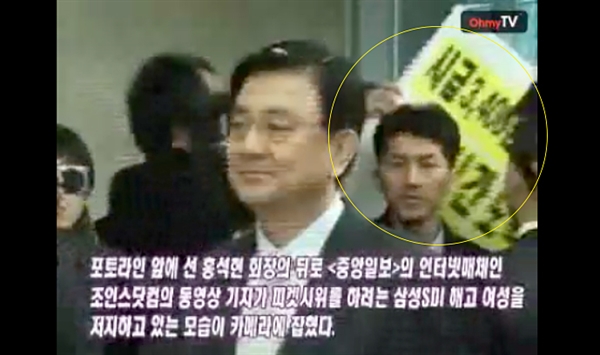 특검에 출석하는 홍석현 회장 뒤로 삼성 SDI 해고 노동자가 피켓 시위를 하려고 하자 <중앙일보> 기자가 저지하고 있다.