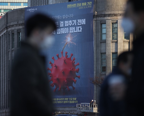 25일 오전 서울도서관 외벽에 천만 시민 긴급 멈춤 기간을 알리는 대형 현수막이 설치되고 있다.