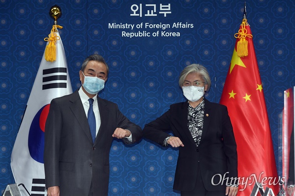 26일 오전 세종로 외교부를 방문한 왕이 중국외교부장이 강경화 외교부장관과 회담 전 팔꿈치 인사를 나누고 있다.