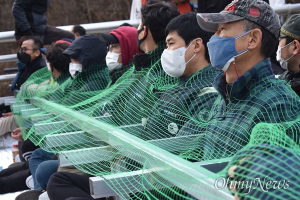 사드가 배치된 경북 성주 소성리 기지에 공사자재를 반입하려 하자 주민들이 기지 입구인 진밭교에서 사다리형 철재를 몸에 두르고 막고 있다.