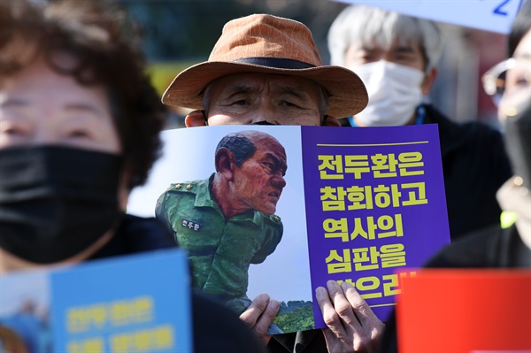 30일 오전 광주 동구 지산동 광주지방법원 앞에서 5·18 민주화운동 관련 단체 회원 등이 전두환 전 대통령의 처벌을 촉구하며 손팻말을 들고 있다. 전씨는 5·18 민주화운동 당시 헬기 사격을 목격했다고 증언한 고(故) 조비오 신부를 회고록에서 비난하고 명예를 훼손한 혐의로 재판에 넘겨져 이날 1심 선고를 받는다.