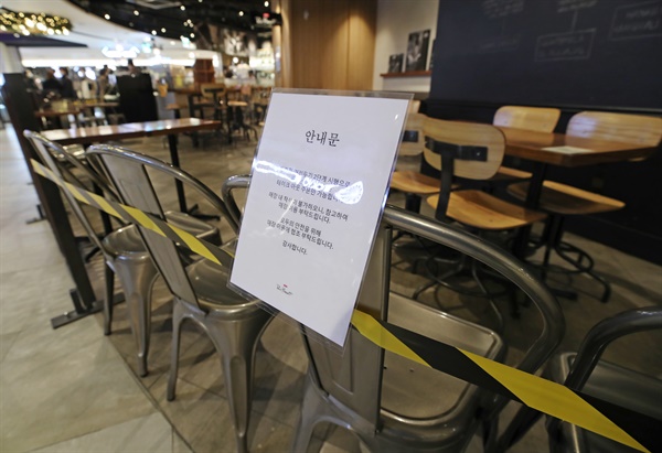 수도권 사회적거리두기 2단계 격상 사흘째인 2020년 11월 26일 서울 시내의 한 대형 쇼핑몰에 입점한 카페 테이블에 고객들의 취식을 막는 테이프가 설치돼 있다. 