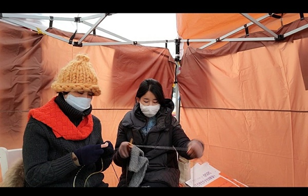 여성폭력근절을 위해 현장을 방문한 함효정회원이 천막안에서  뜨개평화 시위에 참여하고 있다.