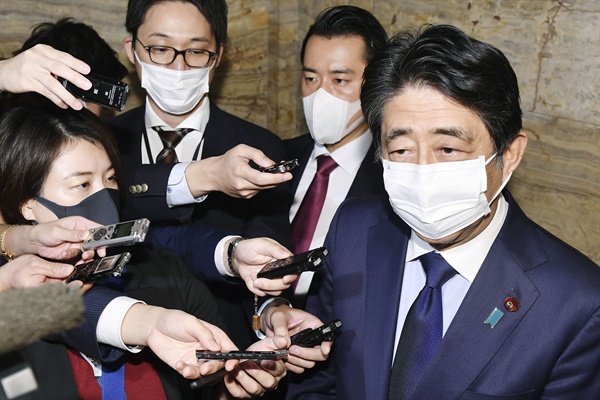 2020년 11월 24일 오후(현지시간) 일본 국회에서 아베 신조(安倍晋三) 전 일본 총리가 기자들의 질문에 답하던 모습. 양복에 달린 푸른 리본이 보인다.