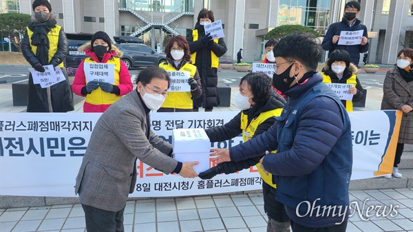 '홈플러스폐점 매각저지 대전공동행동'은 8일 오후 대전시청 북문 앞에서 '홈플러스 폐점매각저지 대전시민 서명용지 전달 기자회견'을 개최했다. 사진은 최재근 대전시 민생정책자문관(왼쪽)에게 서명지를 전달하는 모습.