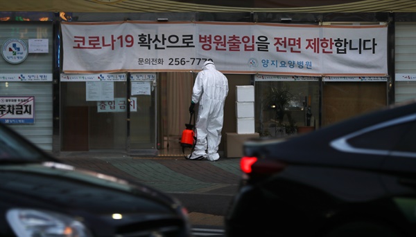  지난 10일 오후 코로나19 확진자 43명이 추가돼 하루에만 47명이 확진 판정을 받은 울산시 남구 양지요양병원 앞에서 방호복을 입은 병원 관계자가 소독하고 있다. 