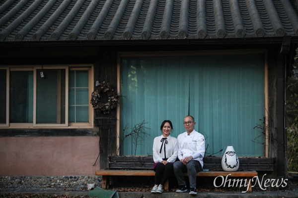 <작은 가게에서 진심을 배우다>의 저자인 김윤정 '고기리막국수' 대표와 남편 유수창 대표가 옛 고기리막국수 가게 앞에서 기념촬영을 하고 있다.