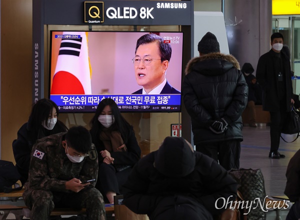  시민들이 11일 오전 서울 용산구 서울역 대합실에서 TV 모니터를 통해 문재인 대통령의 신년사 생중계를 지켜보고 있다.