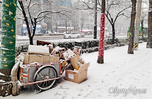 지난 12일 오후, 눈이 내린 서울 시내의 모습. 거리 한편에 놓인 재활용품 수집 리어카에도 하얗게 눈이 쌓였다.  
