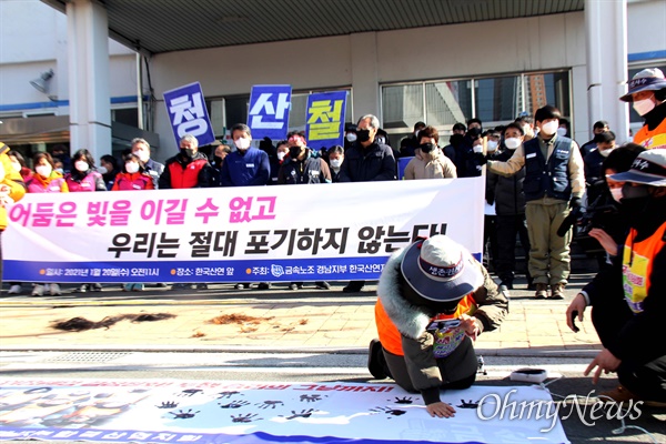 전국금속노동조합 한국산연지회는 20일 창원 마산자유무역지역 내 한국산연 출입문 앞에서 '폐업 철회' 기자회견을 열었고, 조합원들이 투쟁을 다짐하며 손도장을 찍고 있다.