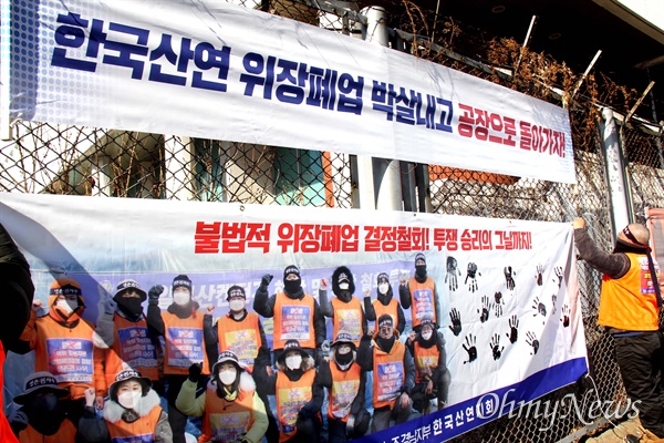 전국금속노동조합 한국산연지회는 20일 창원 마산자유무역지역 내 한국산연 출입문 앞에서 '폐업 철회' 기자회견을 열었고, 조합원들이 투쟁을 다짐하며 손도장을 찍은 펼침막을 걸고 있다.