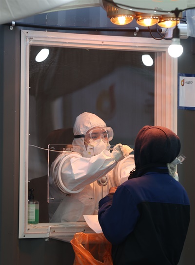20일 오전 서울역 광장에 마련된 코로나19 임시선별진료소에서 의료진이 검체 채취를 하고 있다.
