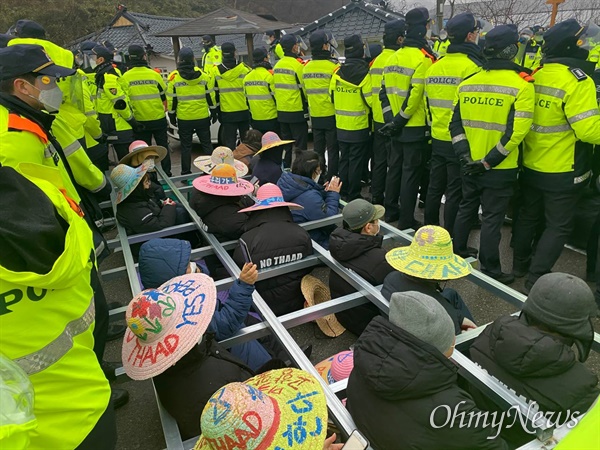 22일 오전 국방부가 경북 성주 사드 기지에 공사 장비를 반입하려 하자 주민들이 소성리 마을회관 입구 도로에서 사다리형 격자 안에 들어가 차량 통행을 막고 있다.